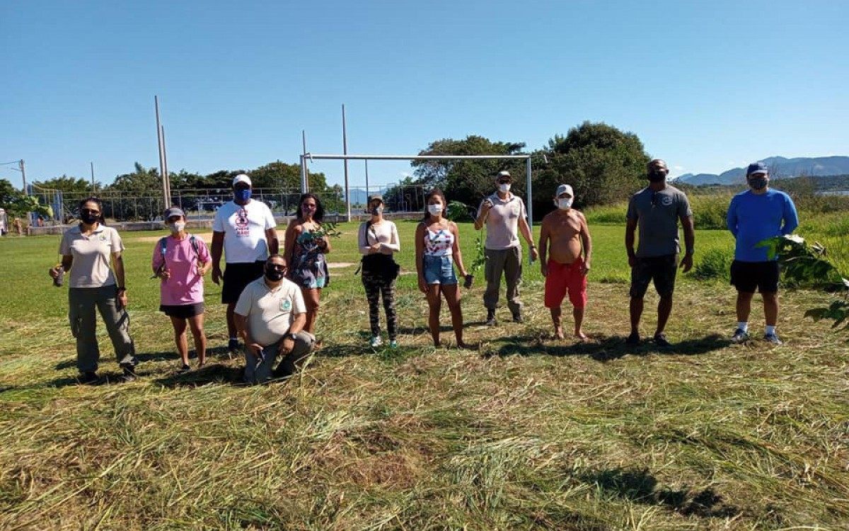 volunt&aacute;rios plantam mudas em torno da lagoa de Jacarepi&aacute;, em Saquarema