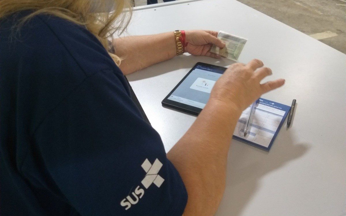 Agente de saúde anota os dados de quem recebe a primeira dose da vacina contra a covid-19