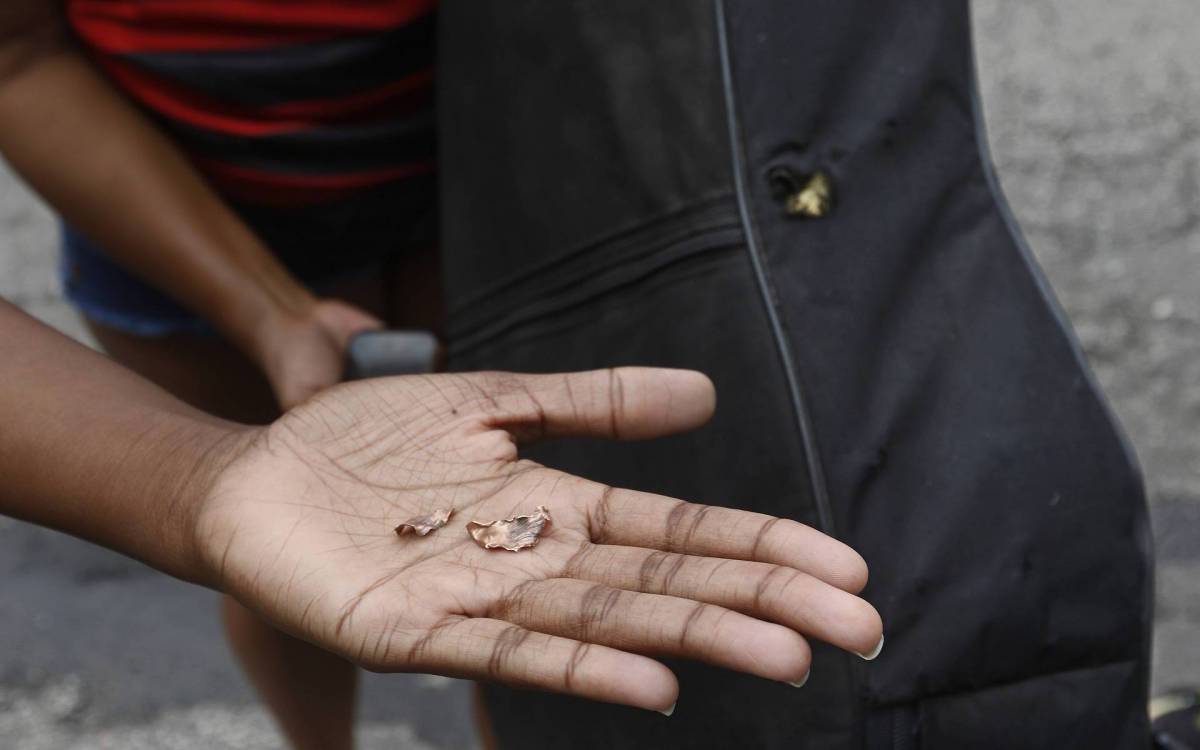 Policia - Opera&ccedil;ao Policial contra trafico no Complexo da Penha, na zona norte do Rio. Na foto, Carol, prima de Thiago, mostra estilha&ccedil;o do projetil e tambem um violao com marca do tiro, que segundo ela, teria atingido a cabe&ccedil;a de seu primo.