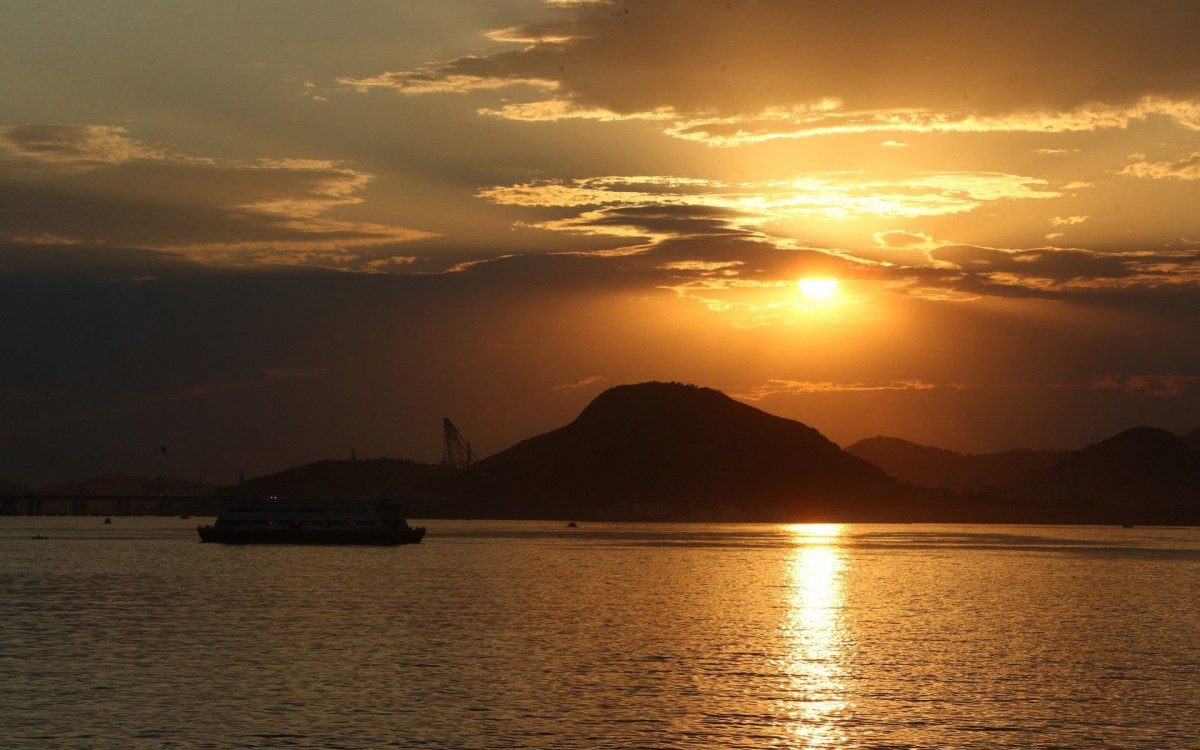 De Barca a caminho da Ilha de Paquetá  vendo o nascer do sol na Baía de Guanabara - banco de imagens o dia