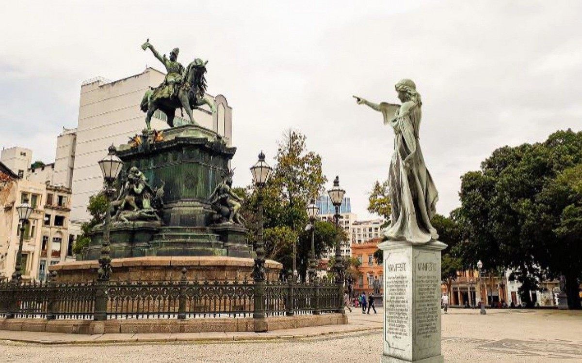 Princesa Leopoldina direciona o dedo para estátua de Dom Pedro I, denunciando as violências sofridas por ela. Escultura foi instalada na Praça Tiradentes
