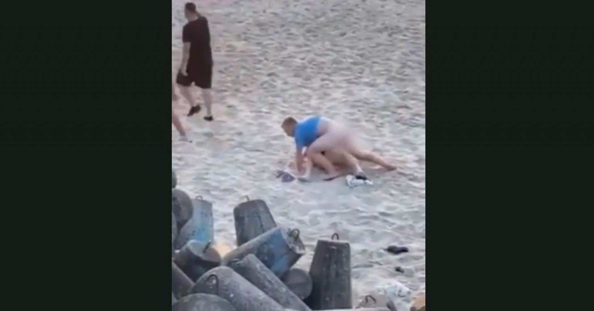 Após ser interrompido pelos banhistas, o homem se distanciou um pouco da parceira - Reprodução de vídeo