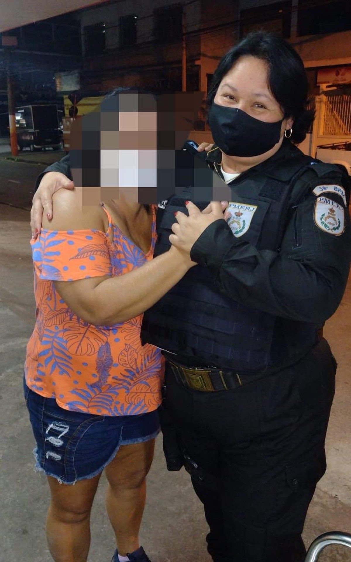 A mulher confortada pela policial militar que a impediu de se jogar do Viaduto da Bayer