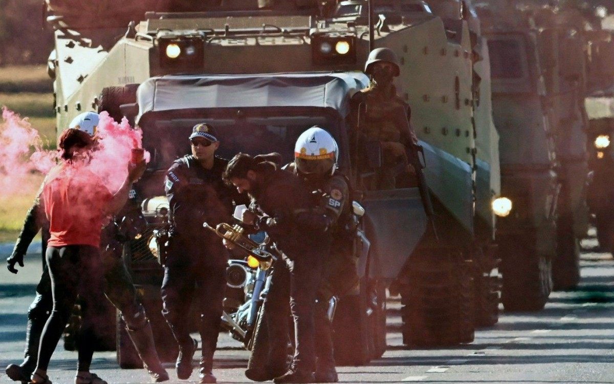 Homem é preso durante desfile de carros blindados militares - AFP