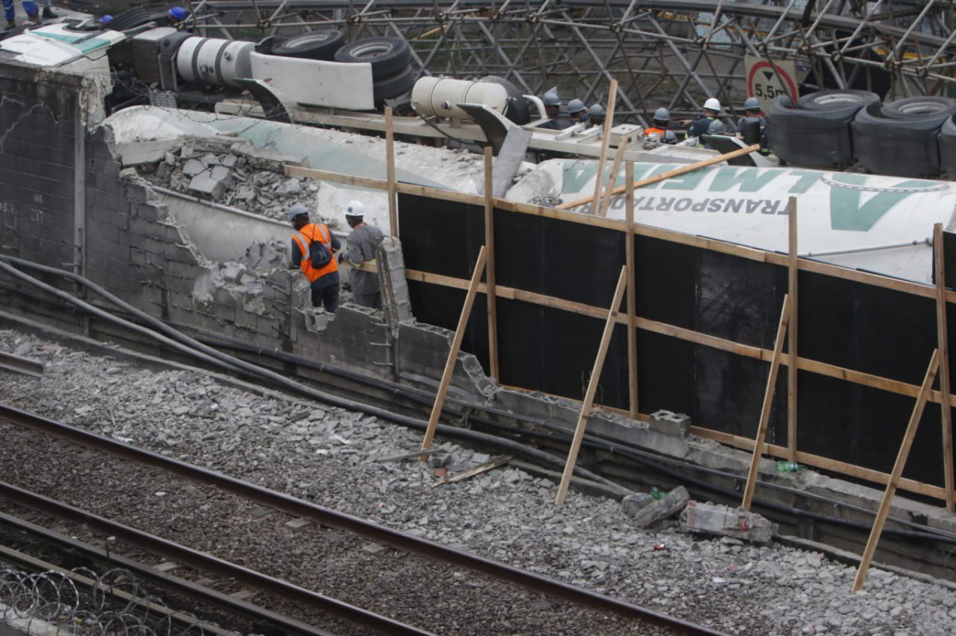 Agentes da prefeitura e funcionários do MetrôRio trabalham na retirada da passarela que caiu sobre os trilhos, em Acari - REGINALDO PIMENTA/AGÊNCIA O DIA