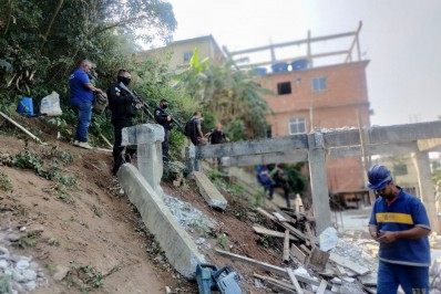 Policiais fazem a segurança de demolição de construções irregulares no Morro do Cantagalo