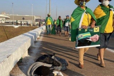 Foto de manifestantes bolsonaristas ao lado de morador em situação de rua em Brasília viraliza