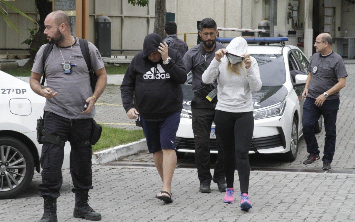 Pol&iacute;cia prende 15 em opera&ccedil;&atilde;o contra a mil&iacute;cia; bando lavava dinheiro at&eacute; com criptomoedas, na foto o casal Luiz Carlos Principe Jr e Cl&eacute;bia Barros Gondim, presos chegando na Cidade da Policia (cidpol),nesta quinta feira (23).