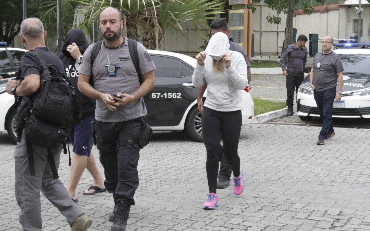 Pol&iacute;cia prende 15 em opera&ccedil;&atilde;o contra a mil&iacute;cia; bando lavava dinheiro at&eacute; com criptomoedas, na foto o casal Luiz Carlos Principe Jr e Cl&eacute;bia Barros Gondim, presos chegando na Cidade da Policia (cidpol),nesta quinta feira (23).