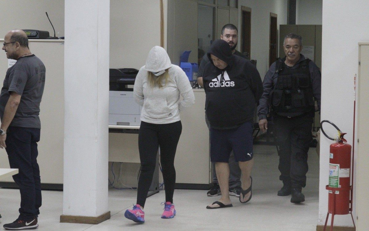 Pol&iacute;cia prende 15 em opera&ccedil;&atilde;o contra a mil&iacute;cia; bando lavava dinheiro at&eacute; com criptomoedas, na foto o casal Luiz Carlos Principe Jr e Cl&eacute;bia Barros Gondim, presos chegando na Cidade da Policia (cidpol),nesta quinta feira (23).