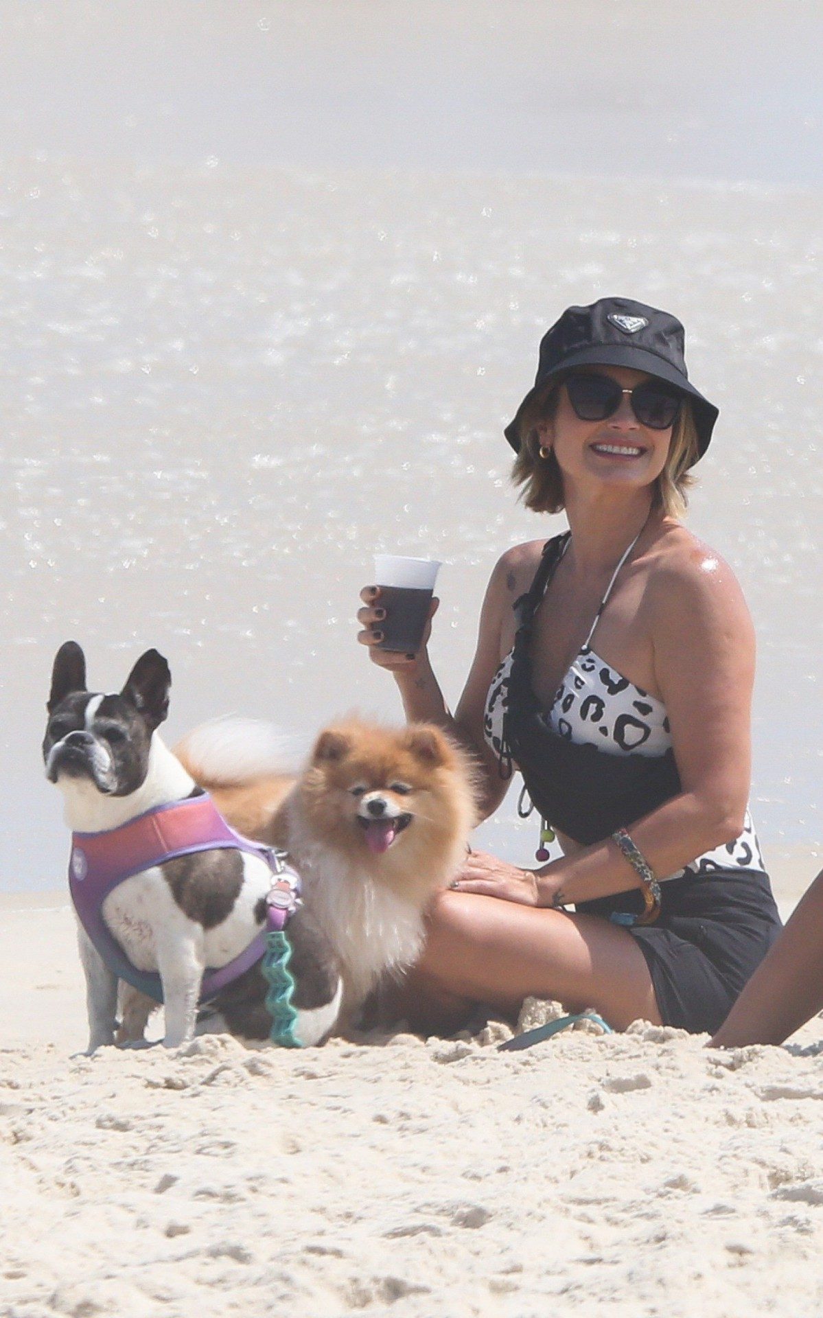 Fl&aacute;via Alessandra e Giulia Costa passeiam com cachorros na praia da Barra da Tijuca