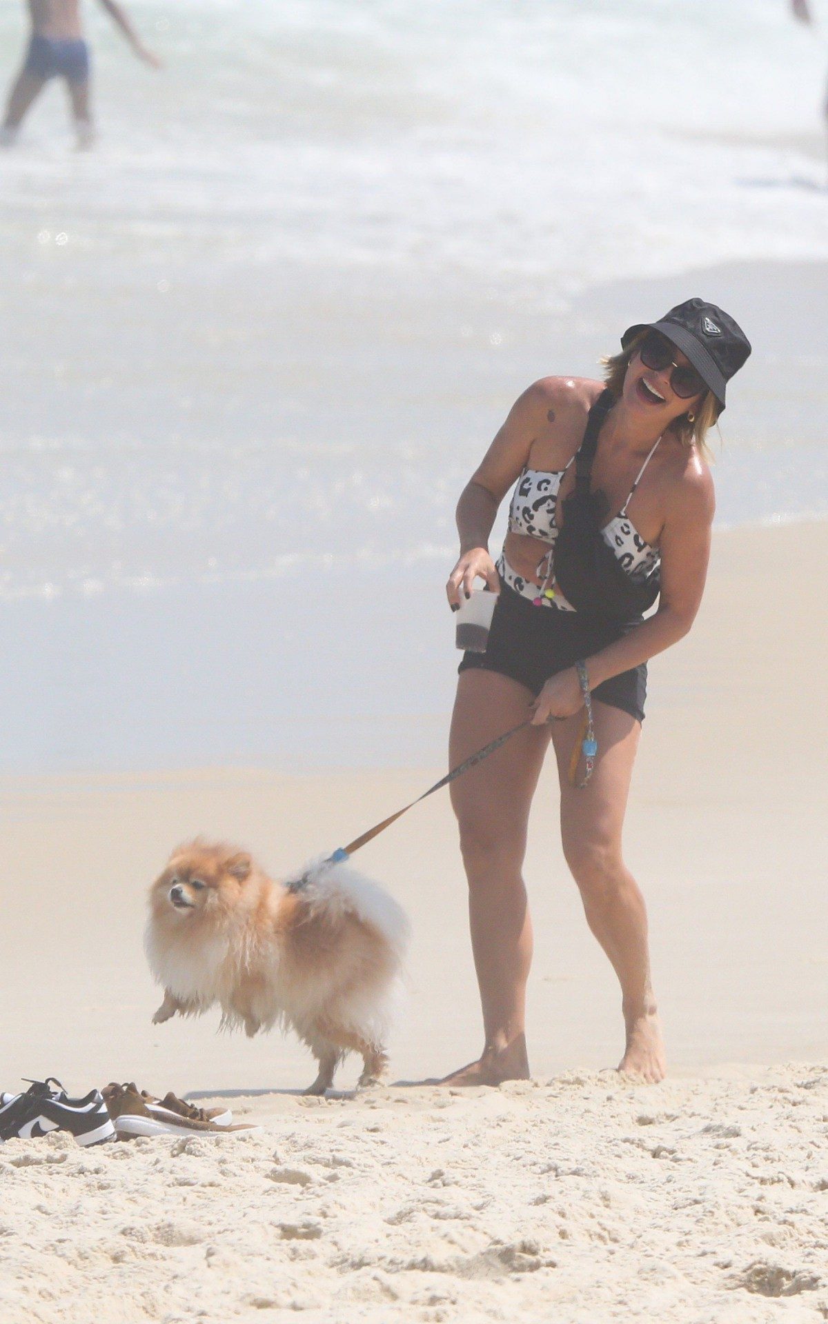 Fl&aacute;via Alessandra e Giulia Costa passeiam com cachorros na praia da Barra da Tijuca