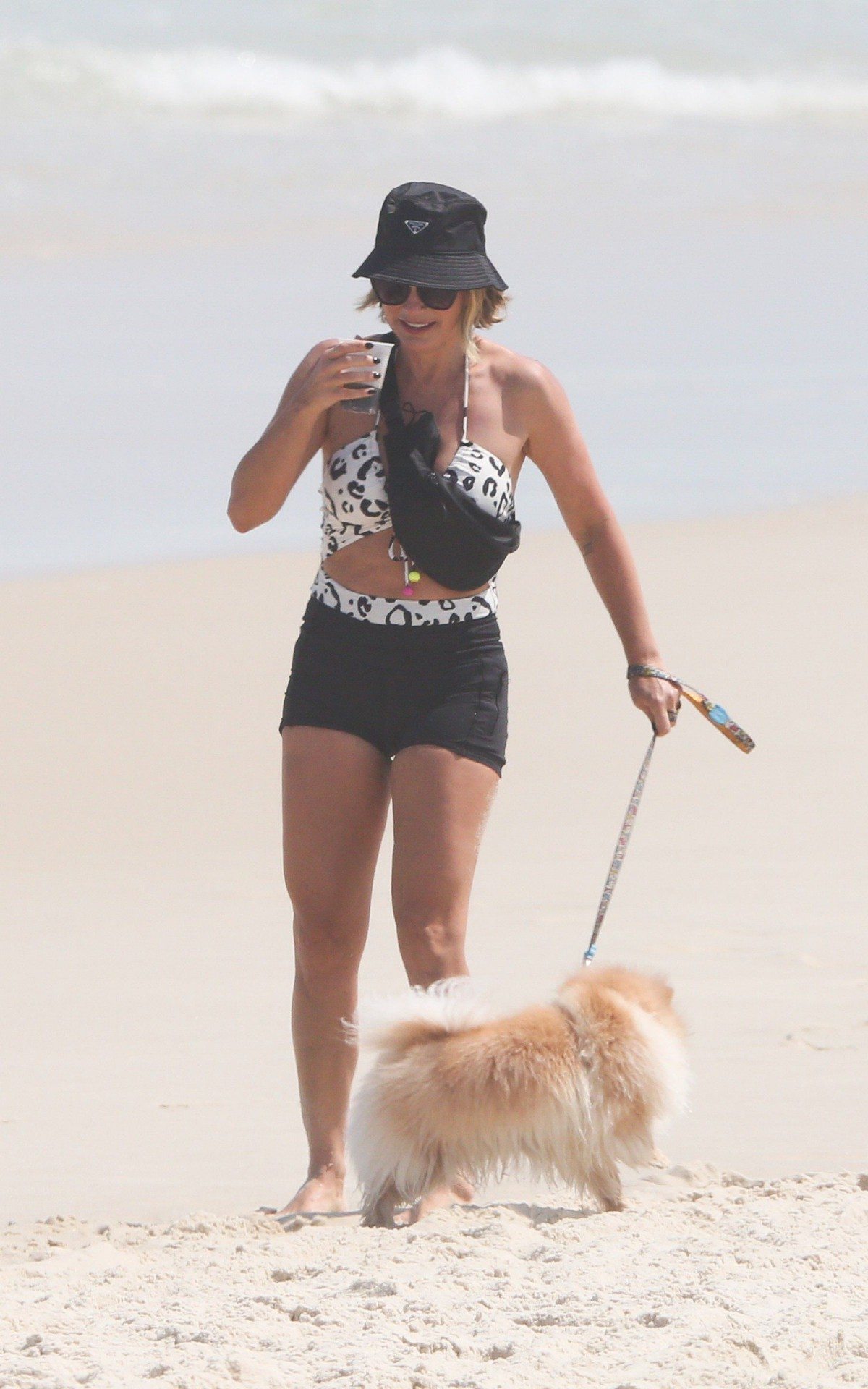Fl&aacute;via Alessandra e Giulia Costa passeiam com cachorros na praia da Barra da Tijuca