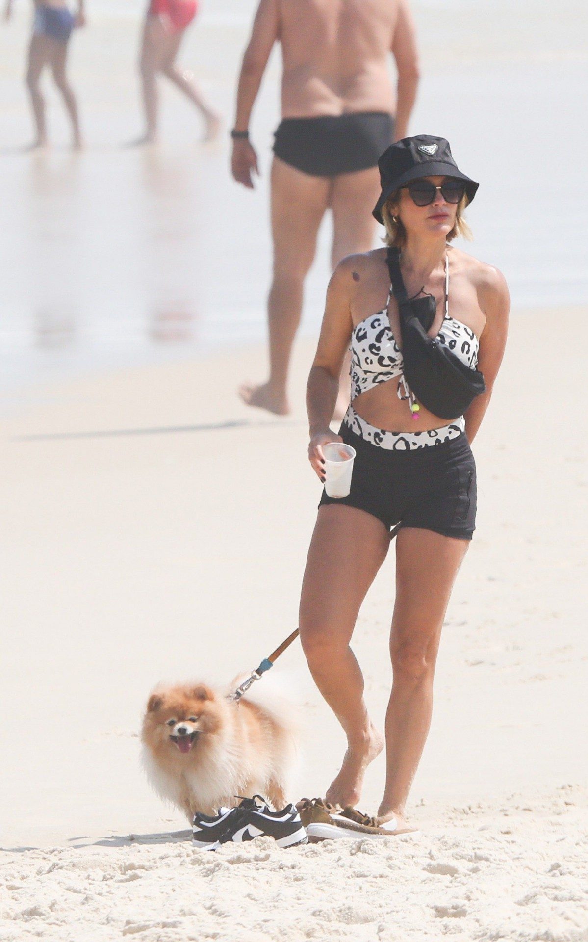 Fl&aacute;via Alessandra e Giulia Costa passeiam com cachorros na praia da Barra da Tijuca