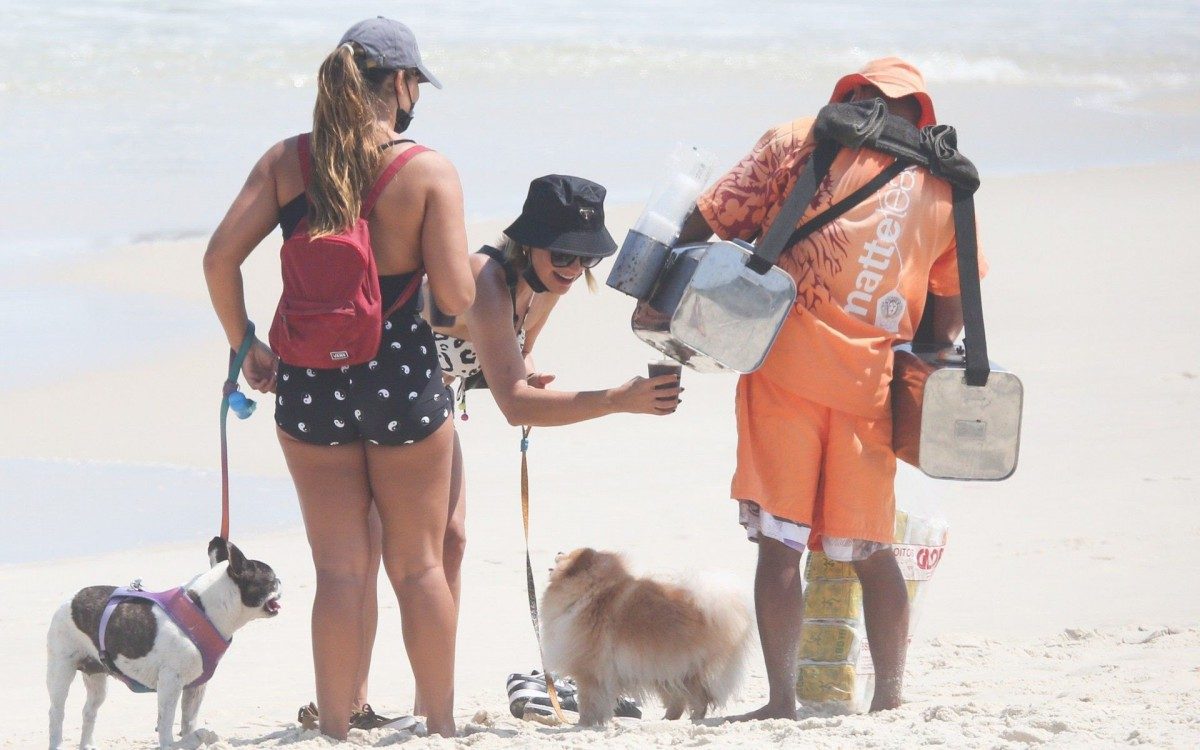 Fl&aacute;via Alessandra e Giulia Costa passeiam com cachorros na praia da Barra da Tijuca