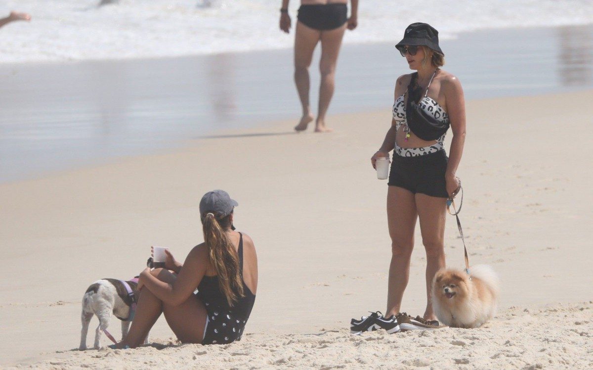 Fl&aacute;via Alessandra e Giulia Costa passeiam com cachorros na praia da Barra da Tijuca