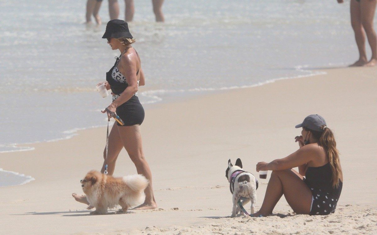 Fl&aacute;via Alessandra e Giulia Costa passeiam com cachorros na praia da Barra da Tijuca