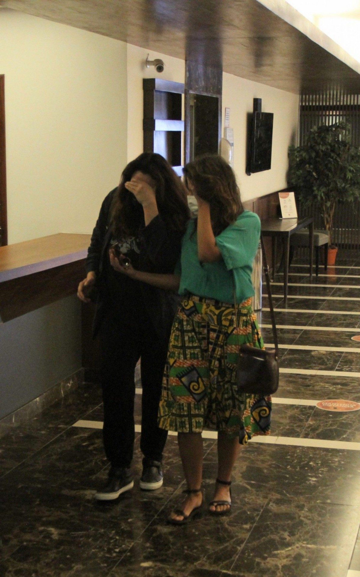 Ana Carolina e a namorada, Chiara Chivello, escondem o rosto ao sair de cl&iacute;nica