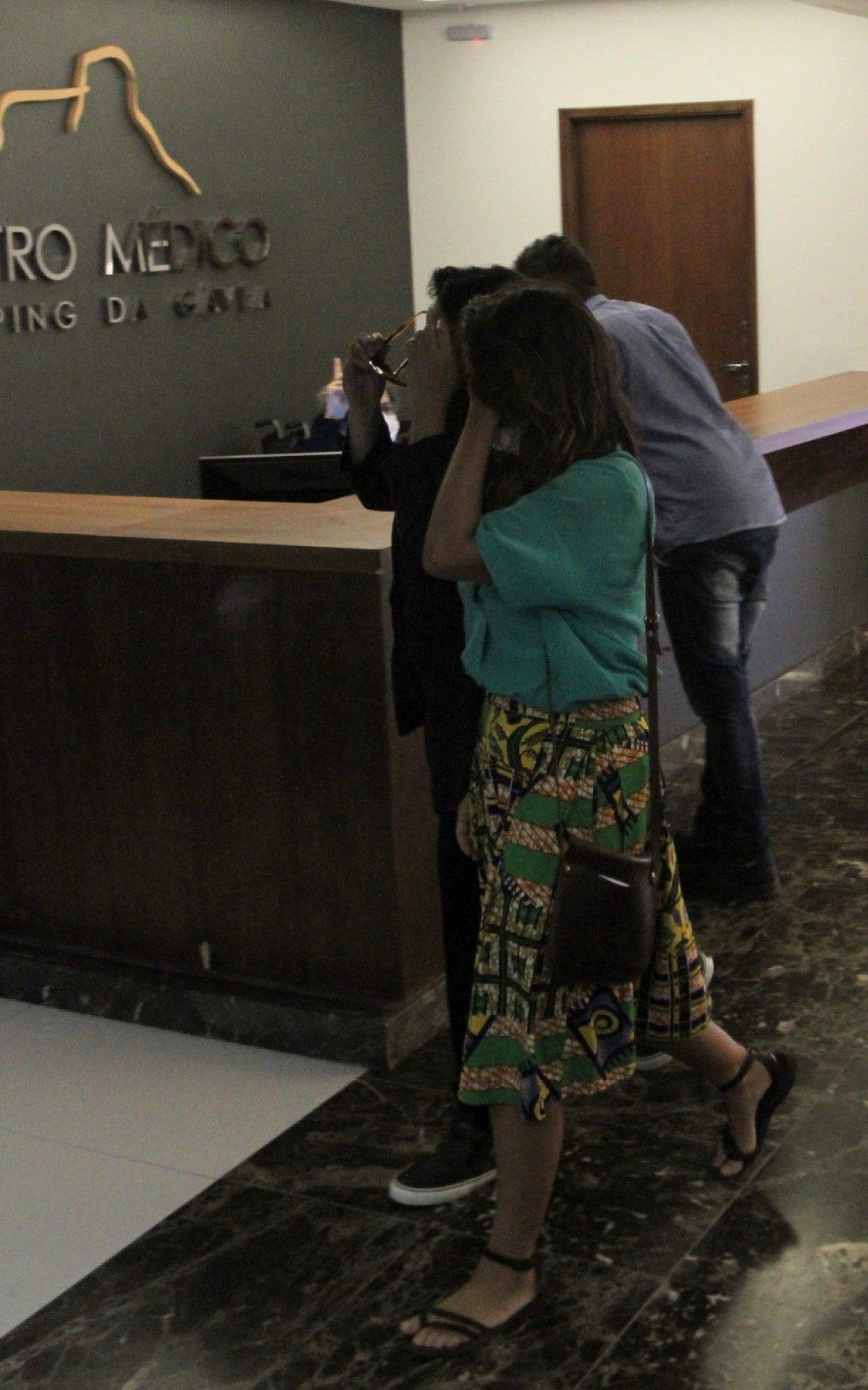 Ana Carolina e a namorada, Chiara Chivello, escondem o rosto ao sair de cl&iacute;nica