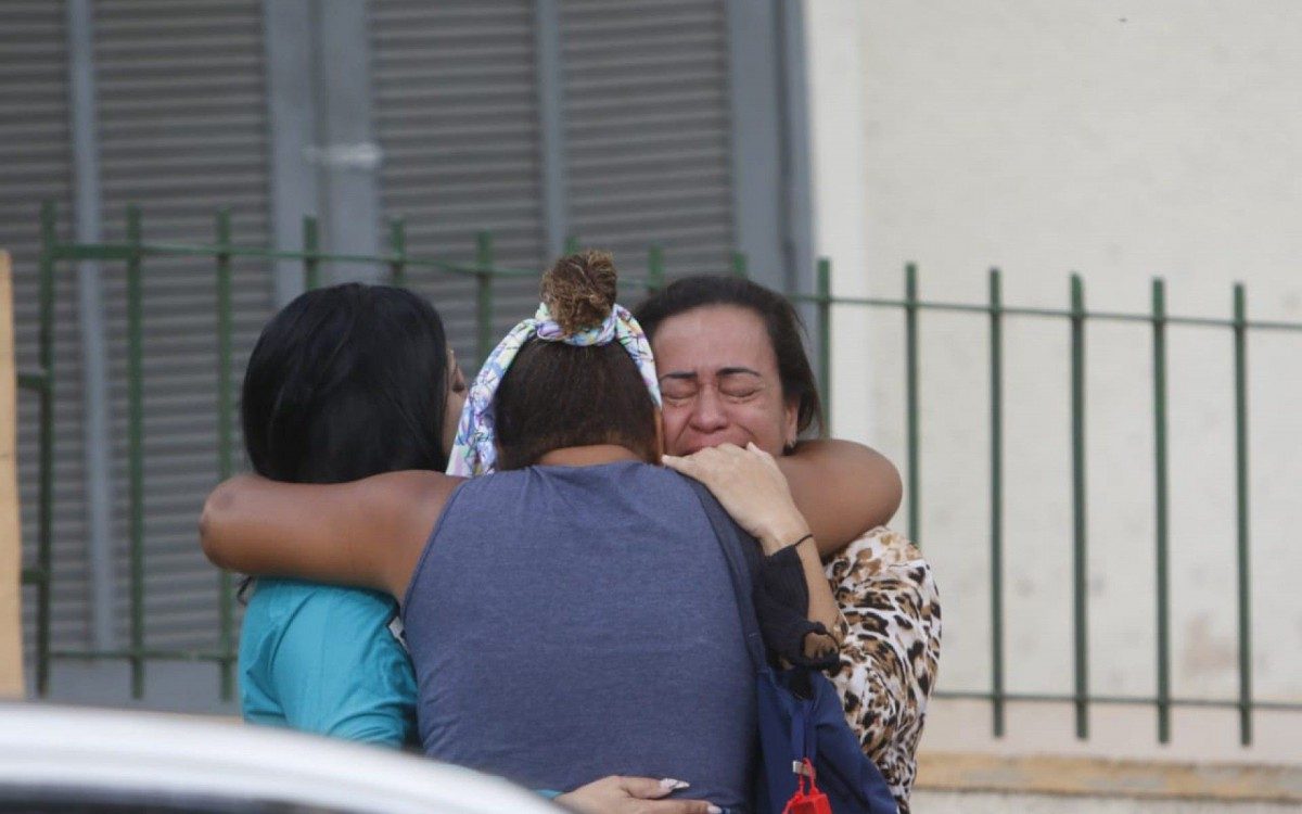 Familiares de Bruno aguardam pela retirada do corpo do frentista do local onde ele foi baleado