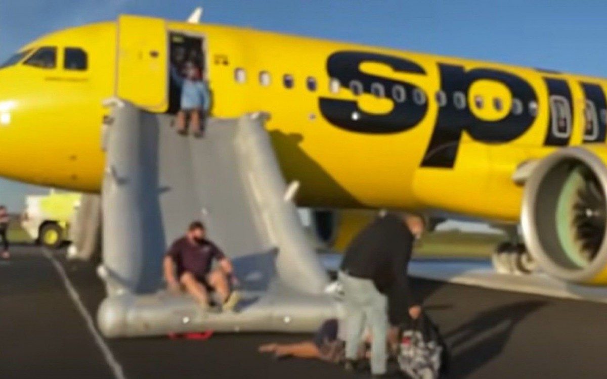 Passageiros descendo pela sa&iacute;da de emerg&ecirc;ncia da aeronave