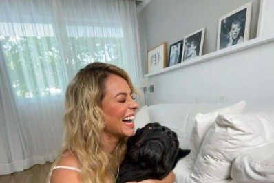 Paolla Oliveira posa sorridente ao lado de seu cachorro
