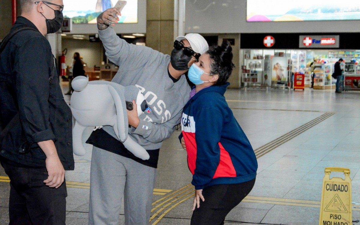 Ludmilla desembarca no Aeroporto do Galeão, no Rio, acompanhada por segurança e posa para fotos com fãs - Ag. News