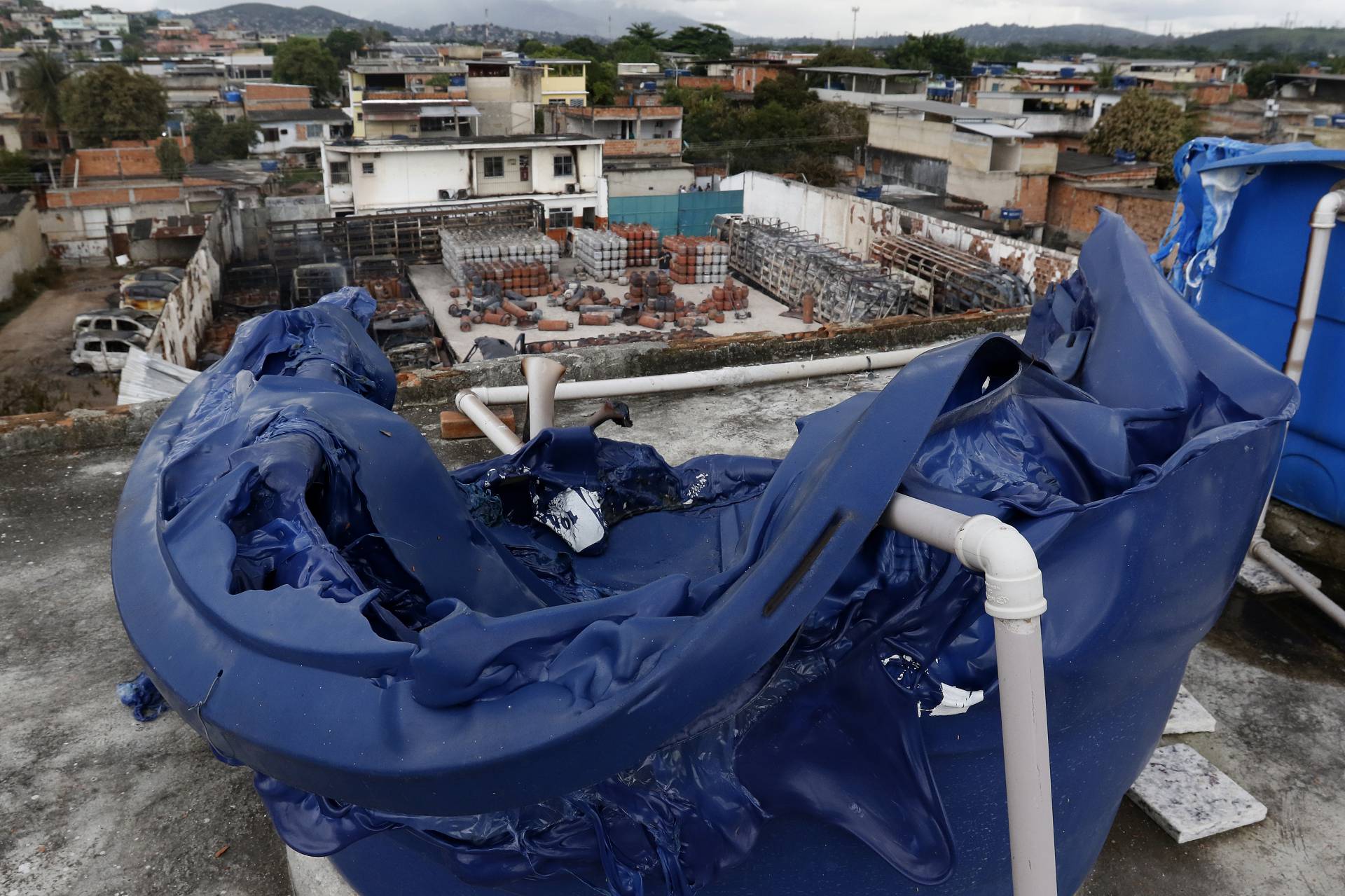 Geral - Incendio de grandes proporçoes atinge deposito de gas em Duque de Caxias, na baixada fluminense, na manha de hoje. Na foto, casa vizinha ao deposito teve quatro caixas dagua derretidas com o calor do incendio. - Reginaldo Pimenta / Agencia O Dia