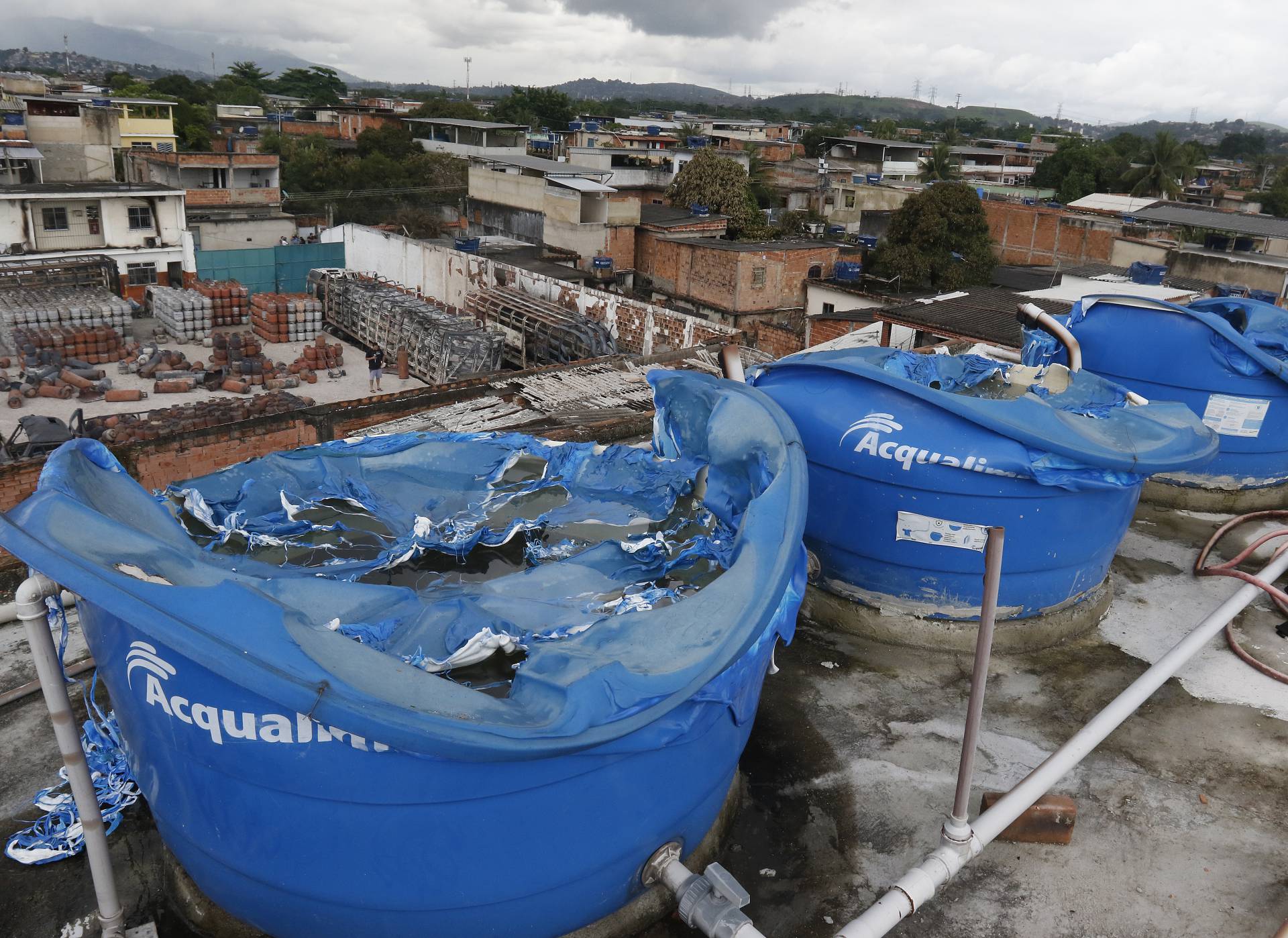 Geral - Incendio de grandes proporçoes atinge deposito de gas em Duque de Caxias, na baixada fluminense, na manha de hoje. Na foto, casa vizinha ao deposito teve quatro caixas dagua derretidas com o calor do incendio. - Reginaldo Pimenta / Agencia O Dia