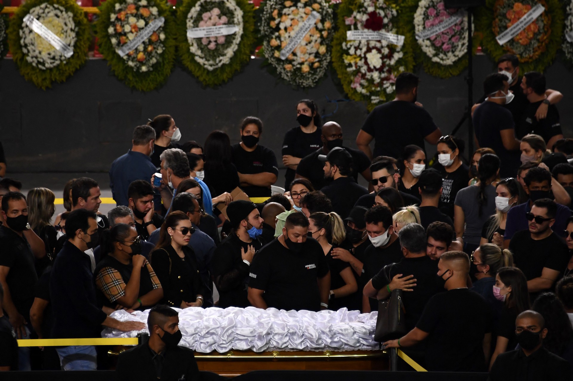 People mourn next to the coffin of Brazilian singer Marilia Mendonca, during her wake at the Arena Goiania sports centre, in Goiania, state of Goias, Brazil, on November 6, 2021. - Marilia Mendonca, 26, one of the most popular of the 