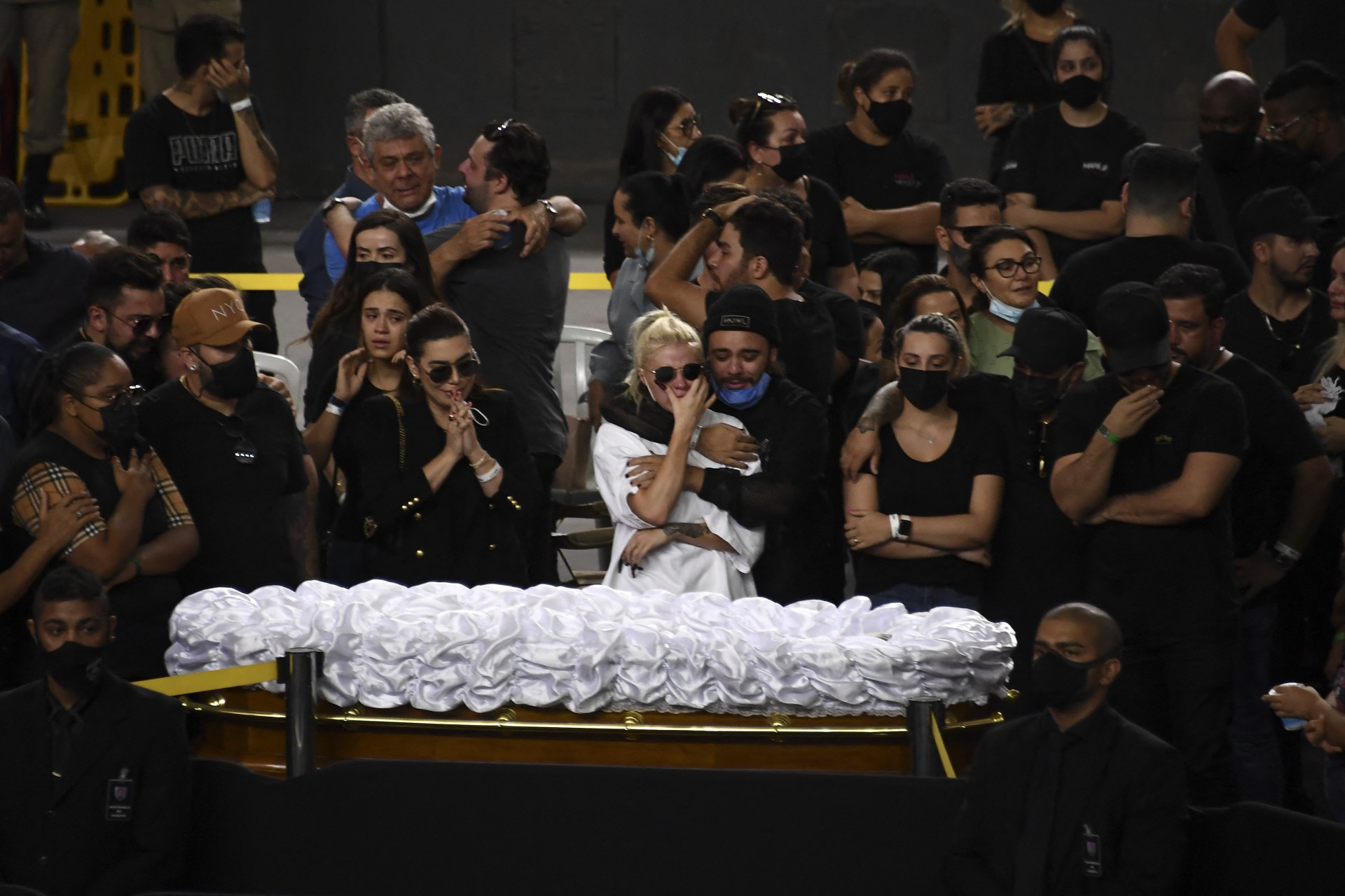 Relatives and friends mourn next to the coffin of Brazilian singer Marilia Mendonca, during her wake at the Arena Goiania sports centre, in Goiania, state of Goias, Brazil, on November 6, 2021. - Marilia Mendonca, 26, one of the most popular of the 