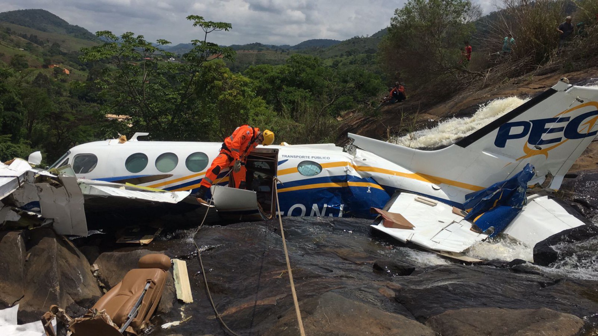 This handout picture released by Minas Gerais Fire Department shows firefighters recovering the belongings of the victims on the wreckage of the crashed plane where the Brazilian singer Marilia Mendonca died on the afternoon in Caratinga, Brazil, on November 6, 2021. - The young Brazilian singer Marilia Mendonca, one of the most popular of the 