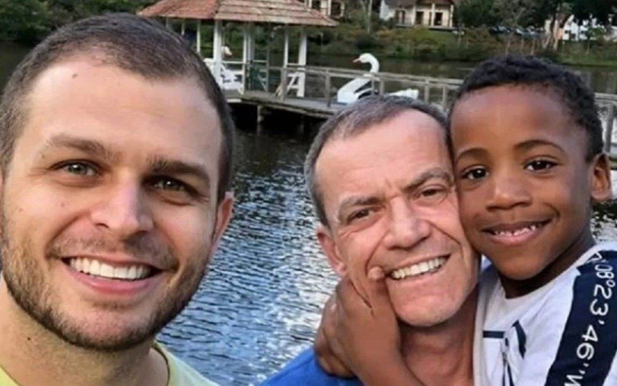 Senador &agrave; direita com o filho; ao lado, o marido dele