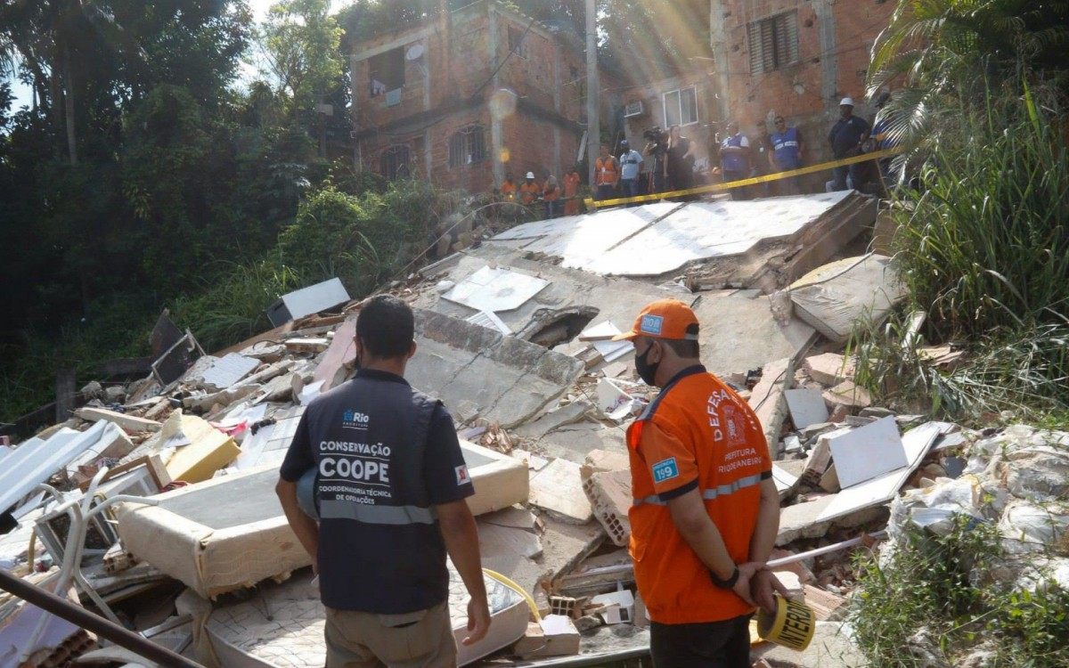 Técnicos da Secretaria Conservação e funcionários da Comlurb fazem a limpeza do terreno no Morro do Salgueiro, onde um imóvel de três andares caiu, na noite de quarta (17). Um homem morreu