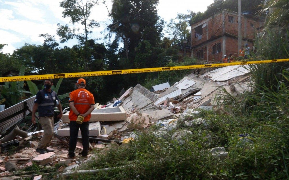 Técnicos da Secretaria Conservação e funcionários da Comlurb fazem a limpeza do terreno no Morro do Salgueiro, onde um imóvel de três andares caiu, na noite de quarta (17). Um homem morreu