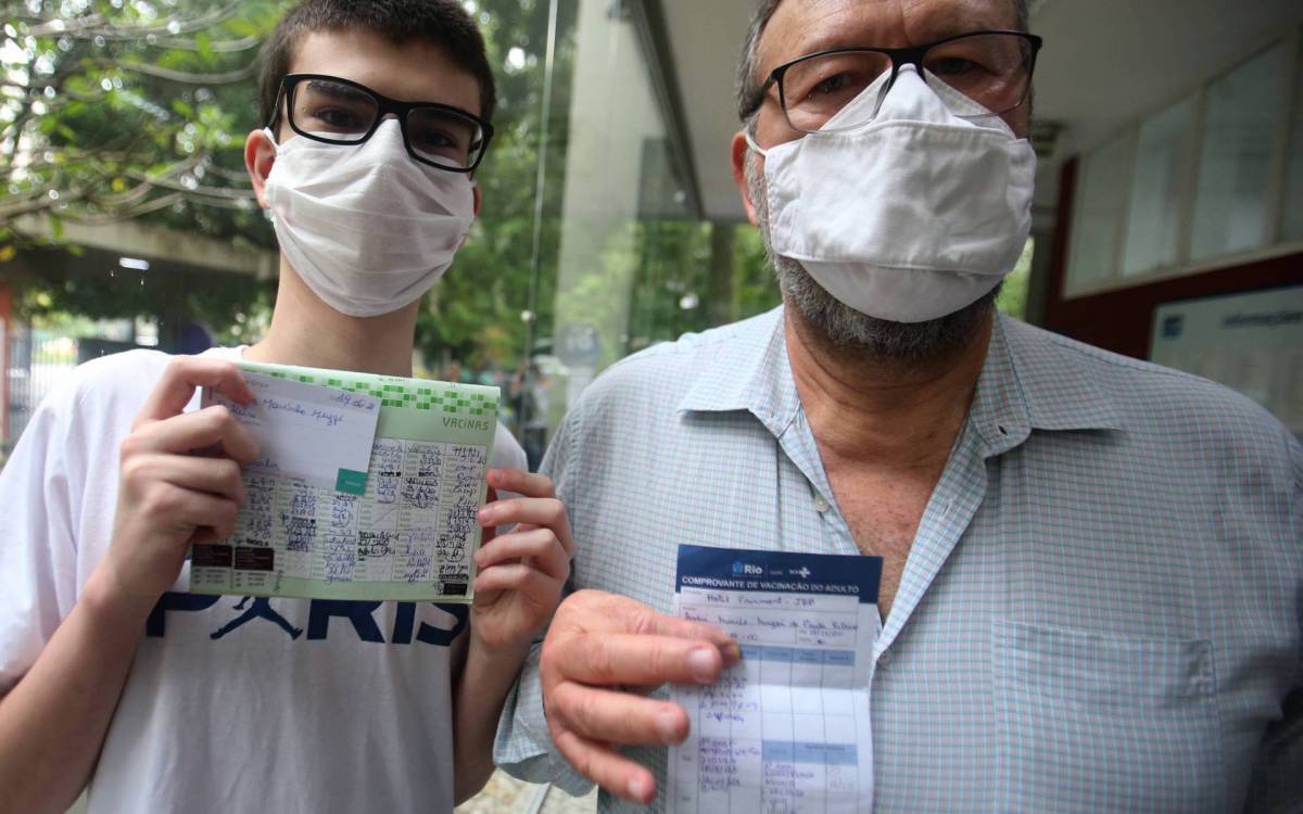 Rio,19/11/2021-GAVEA,Centro Municipal de Saude Pindaro de Carvalho Rodrigues,dose de reforco contra Covid-19, em pessoas com menos de 60 anos, na foto: Andre Murilo de Paula(DR) com seu filho Igor Marinho  Muzzi (segunda dose).Foto: Cleber Mendes/Ag&ecirc;ncia O Dia