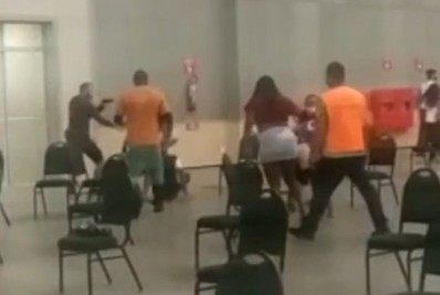 Homem aponta arma em uma fila de vacinação contra covid-19