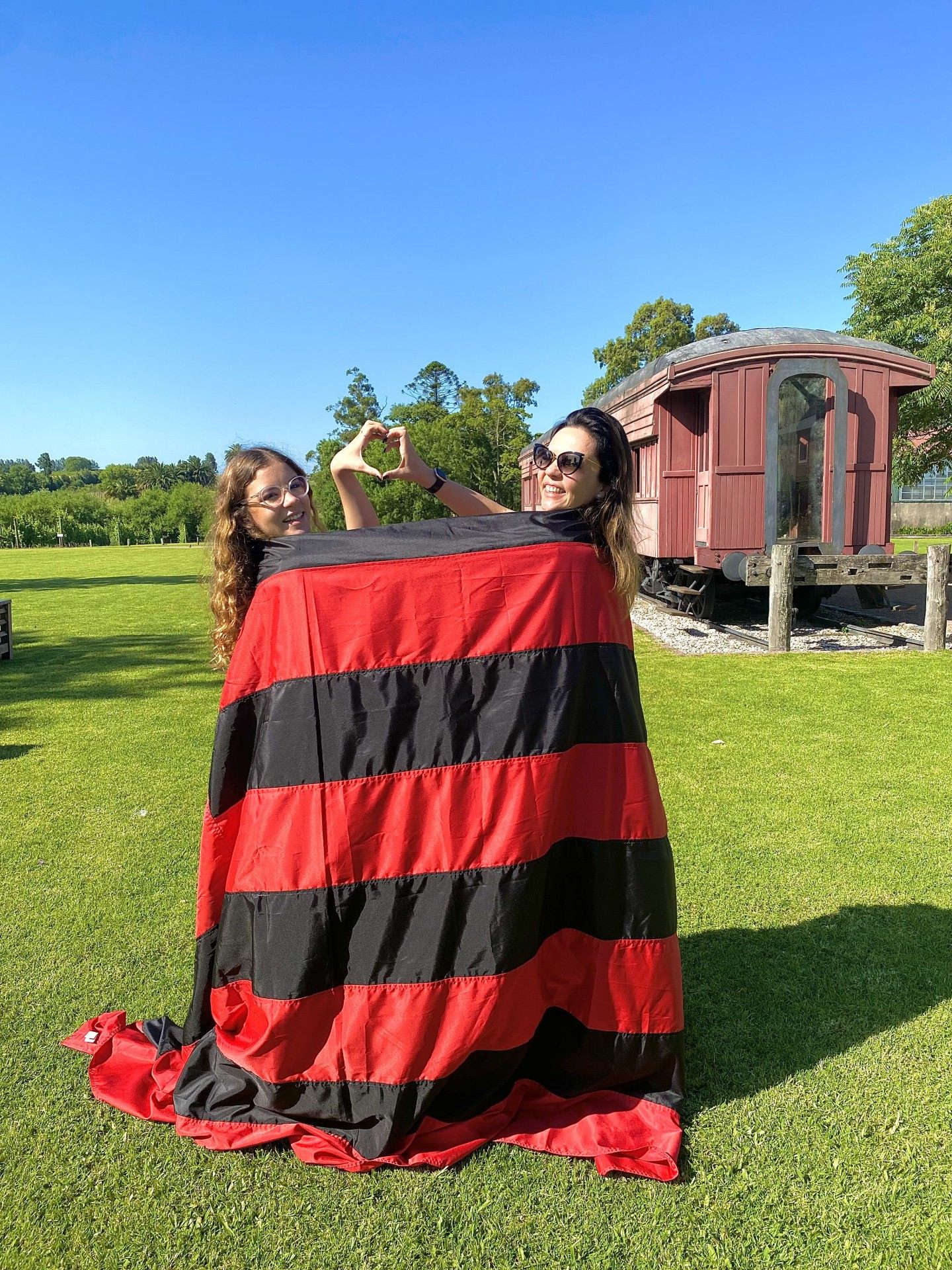Mãe e filha, Cida e Lara Amaral, posam com a bandeira do Flamengo, no Uruguai - Gardênia Cavalcanti