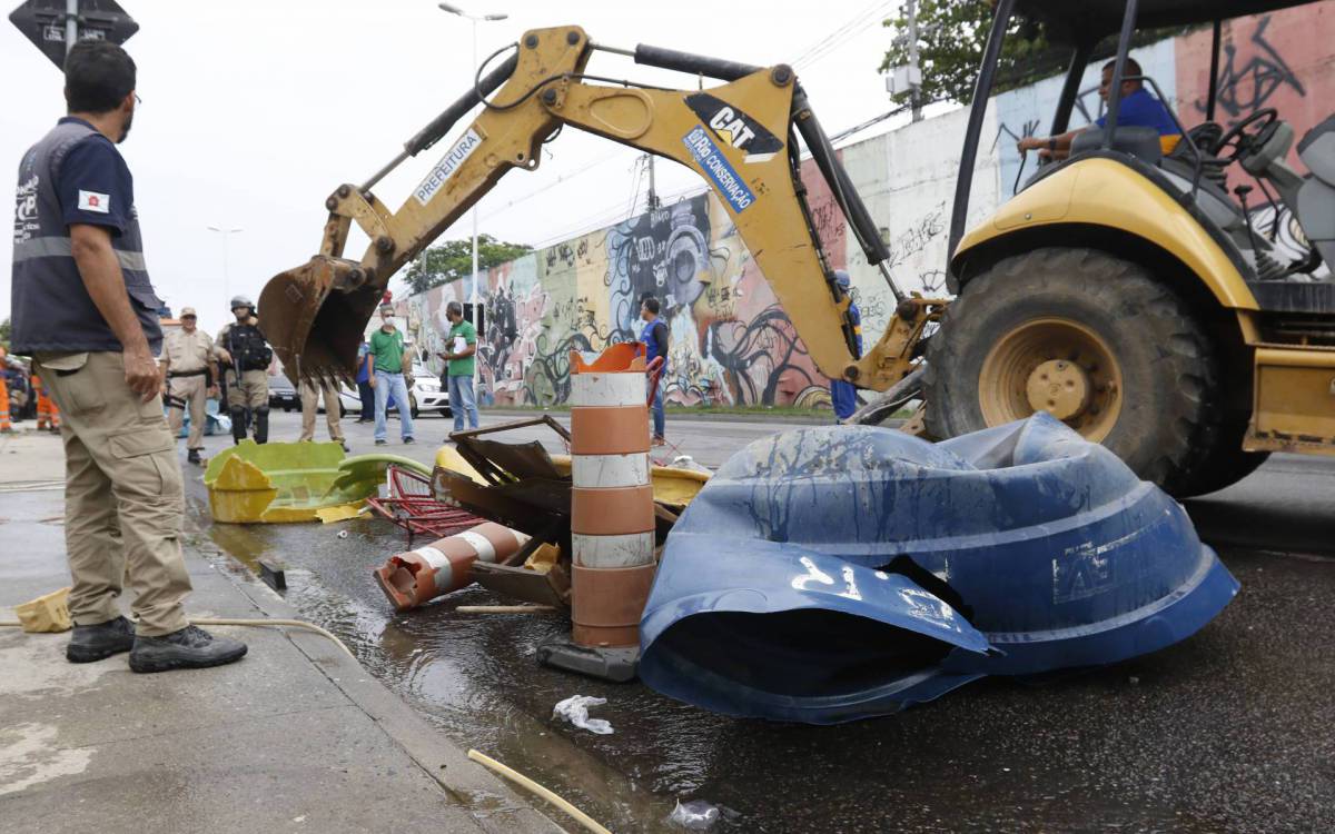 Policia - Operaçao foi realizada pela 21ªDP (Bonsucesso), nesta terça-feira, em conjunto com a Policia Militar e com a Prefeitura do Rio. Durante as investigaçoes, policiais constataram que a atividade era explorada pelo trafico de drogas da regiao. Alem disso, os estabelecimentos utilizavam agua e energia furtadas. Moradores da comunidade do Mandela colocaram fogo em destroços, na Rua Leopoldo Bulhoes, na Zona Norte do Rio, apos a megaoperaçao que destruiu os lava-jatos clandestinos da regiao. - Reginaldo Pimenta / Agencia O Dia