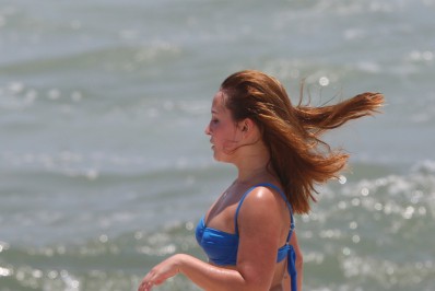 Em dia de sol forte, Larissa Manoela se refresca no mar após treino de futevôlei