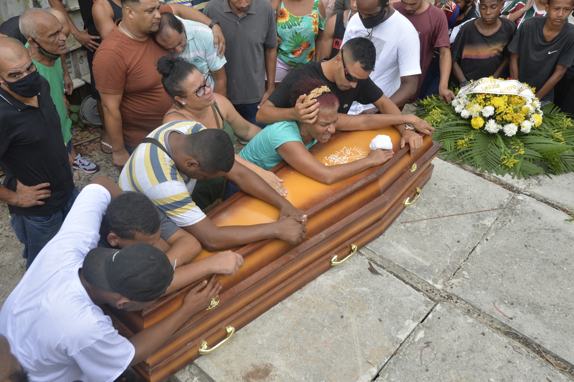 Vestida de verde, a mãe da vítima se desespera sobre o caixão no enterro em cemitério de São Gonçalo - FabioCosta                          