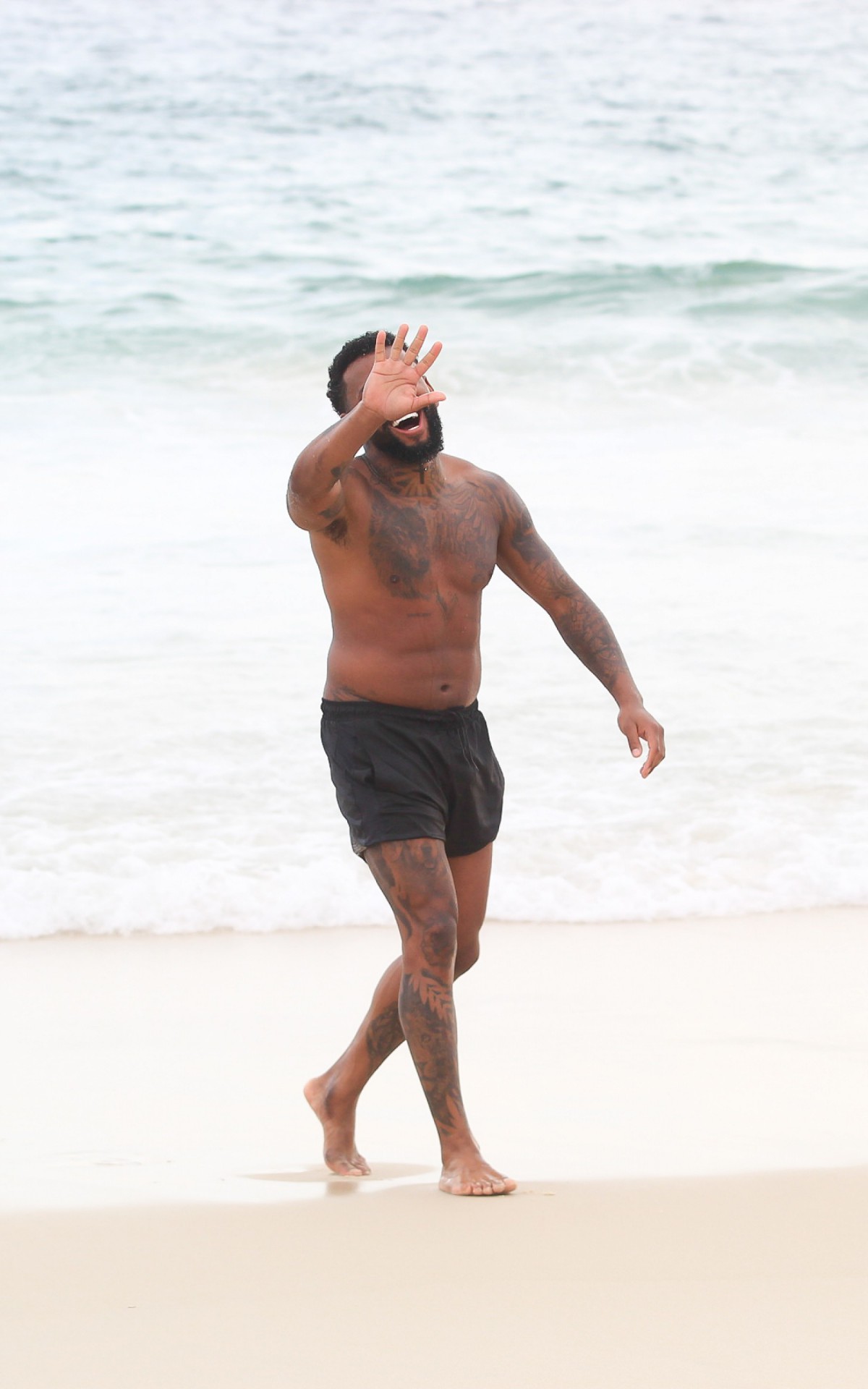 Nego do Borel curte dia de sol na Praia da Barra da Tijuca, na Zona Oeste do Rio, na tarde desta quarta-feira