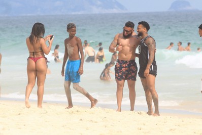 Nego do Borel dá mergulho no mar e se diverte com amigos na praia