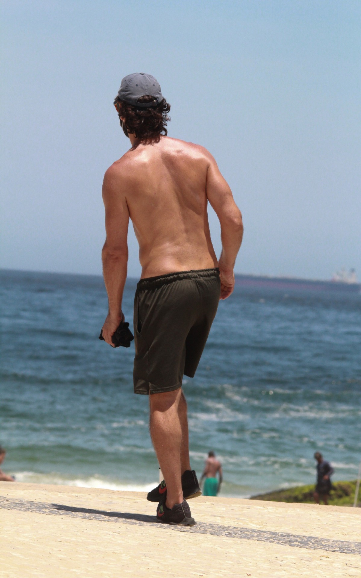 Rodrigo Santoro caminha na orla da praia do Arpoador