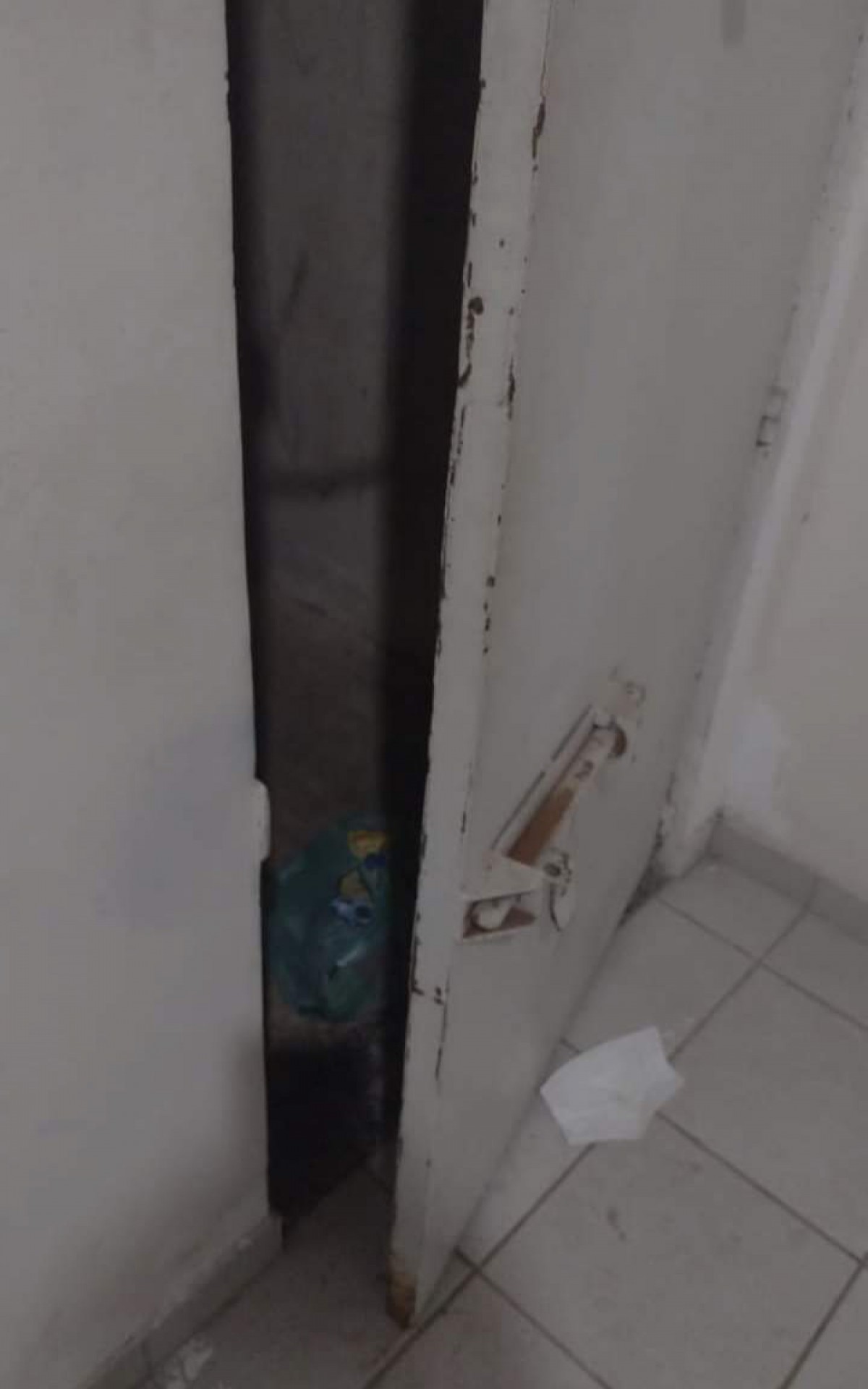 Porta da cela sem a tranca de onde o criminoso conseguiu escapar. A pol&iacute;cia perece querer evitar falar do caso. 