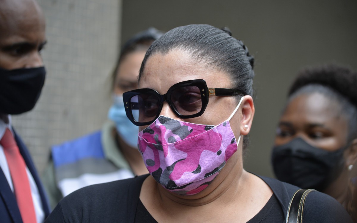 De &oacute;culos escuro e m&aacute;scara rosa, Luziane Te&oacute;filo, vi&uacute;va de Durval, assassinado pelo o vizinho, deixa a delegacia de homic&iacute;dios, depois de depor. 