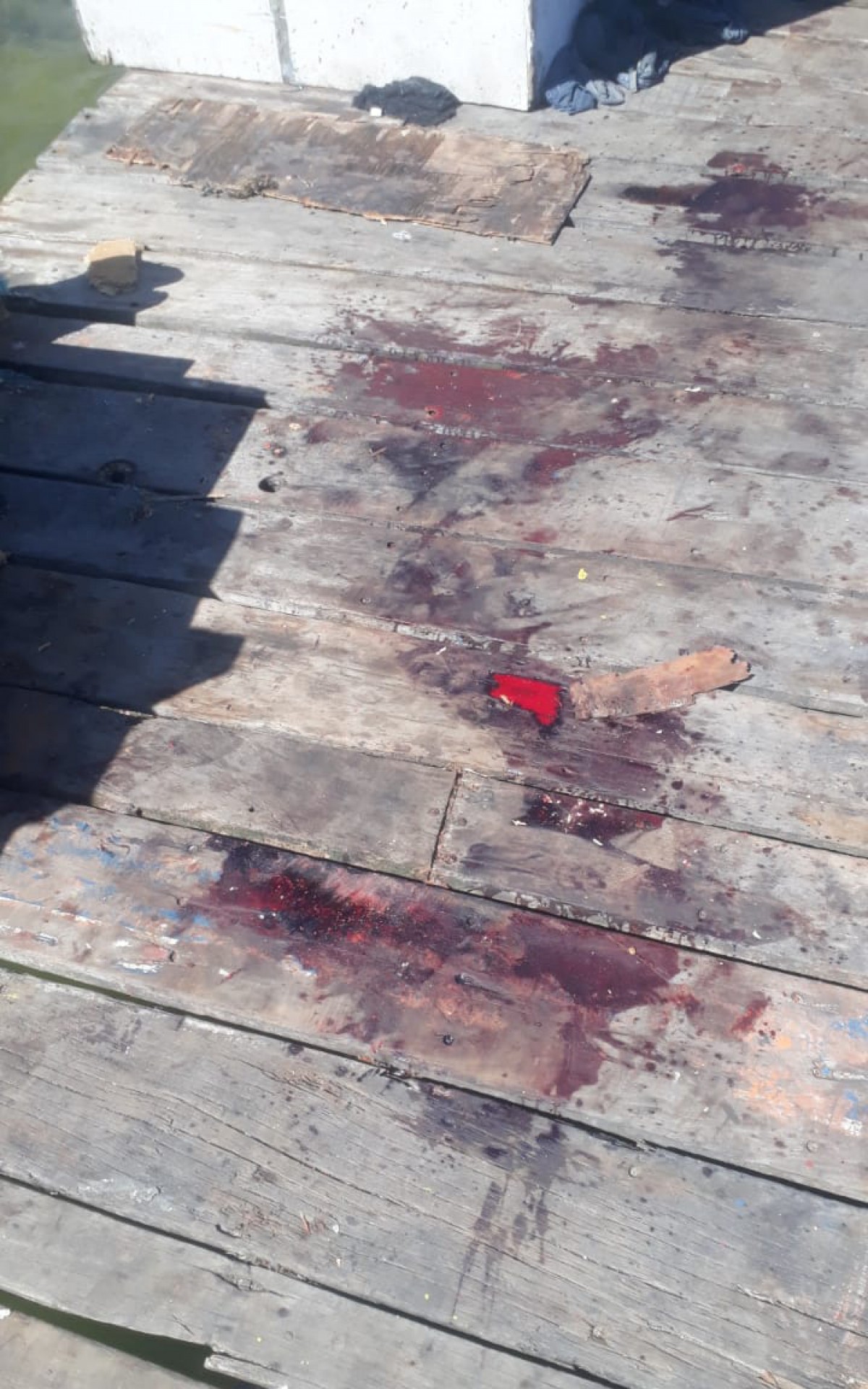 Marcas de sangue no deck revelam viol&ecirc;ncia. A v&iacute;tima tinha marcas de facadas no corpo