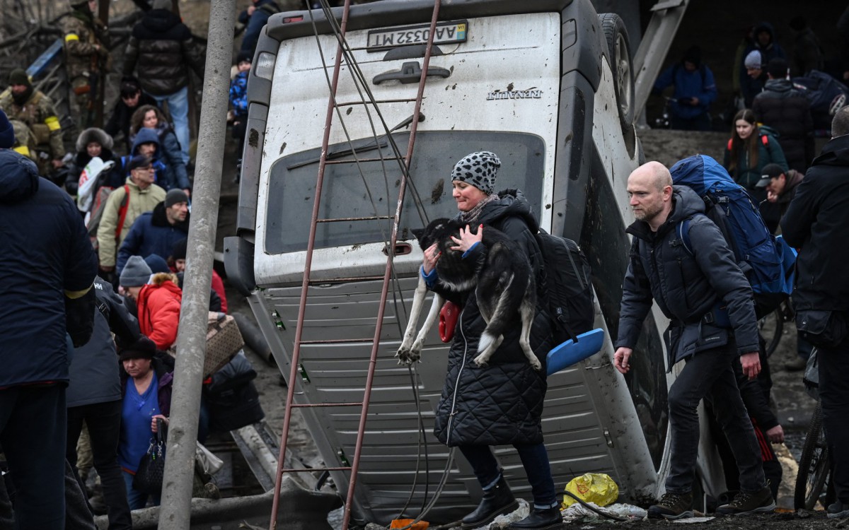UKRAINE-RUSSIA-CONFLICT
A woman carries a dog while people cross a destroyed bridge as they evacuate the city of Irpin, northwest of Kyiv, during heavy shelling and bombing on March 5, 2022, 10 days after Russia launched a military in vasion on Ukraine.
Aris Messinis / AFP - Aris Messinis / AFP