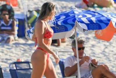 Carol Portaluppi curte praia com o pai e exibe corpão nas areias do Leblon