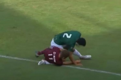 Após bolada na cara, jogador cai, quebra perna de adversário e é expulso